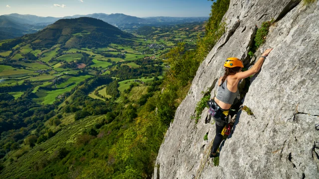 Une sportive escalade la falaise d'Arguibelle à Lanne en Baretous