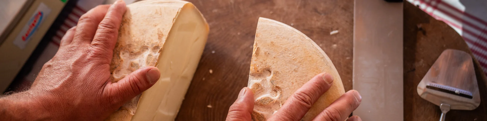 fromage coupé en deux sur un plateau en bois qui est posé sur une table