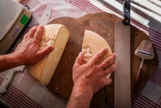 fromage coupé en deux sur un plateau en bois qui est posé sur une table