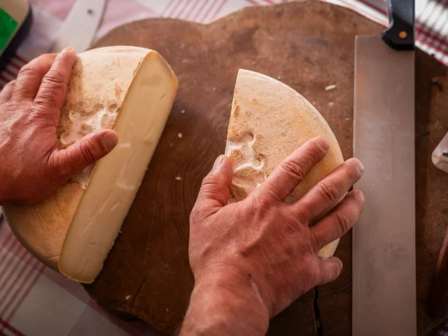 fromage coupé en deux sur un plateau en bois qui est posé sur une table